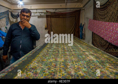 JAIPUR, INDIA - SEPTEMBER 19, 2017: Unidentified man in a room with a block Printing for Textile in India. Block Printing Traditional Process in India. Jaipur, center of Traditional Handicrafts of India