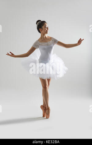 Young smiling woman in ballet clothes posing elegantly Stock Photo