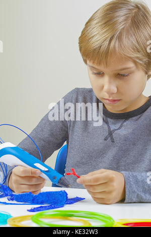 Focused child creating new 3d object with 3d printing pen Stock Photo ...