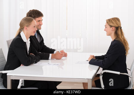 Female Manager Interviewing Young Confident Applicant In Office Stock Photo