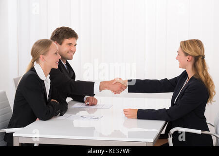 Confident Happy Young Male Applicant Shaking Hands With Manager During Interview Stock Photo