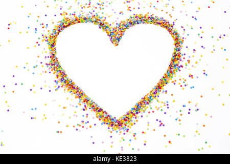 Heart made of colored confetti. Small circles of colored paper. White background. View from above. Colored heart. Stock Photo