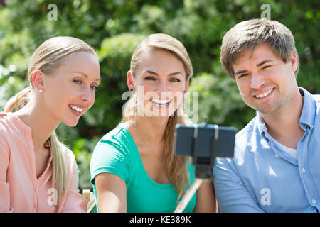 Close-up Of Happy Young Friends Taking Selfie With Selfie Stick Stock Photo