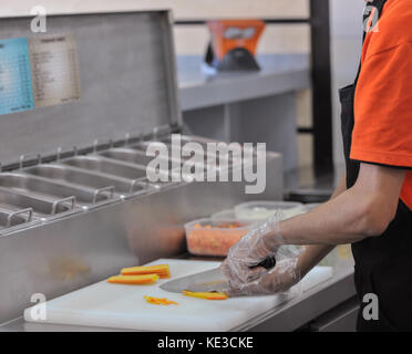 Chef cuts the vegetables in fast food restaurant. cook in the kitchen of the restaurant cut carrots for salad Stock Photo