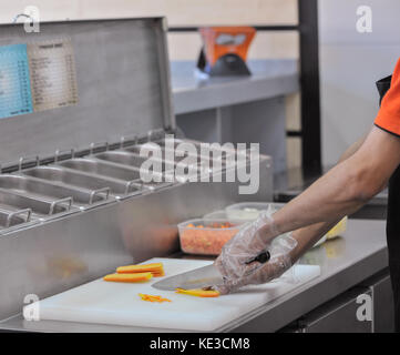 Chef cuts the vegetables in fast food restaurant. cook in the kitchen of the restaurant cut carrots for salad Stock Photo