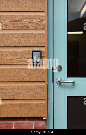 Digital code entry pad at the entrance to a modern care home for the elderly. Mounted on plastic, wood-effect cladding. Stock Photo