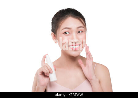 Beautiful model showing applying cosmetic cream treatment on her face Stock Photo