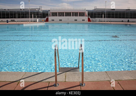 Newly refurbished outdoor swimming pool at Uxbridge Lido and sports centre, London, UK. Shows pool ladder with cafe and changing rooms in background Stock Photo