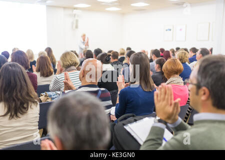 Woman giving interactive motivational speech at entrepreneurship workshop. Stock Photo