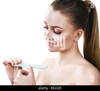 Young woman doing manicure with nail file. Stock Photo