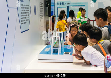 Children learning from interactive science exhibit at a technology fair in Hong Kong SAR Stock Photo