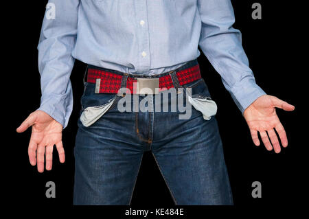 man showing his empty pockets demonstrating he has no money on black isolated background. The guy throws his hands to the sides show the inconsistency Stock Photo