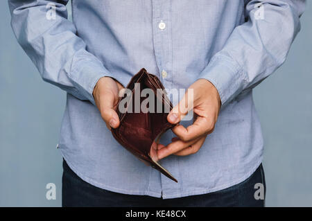 Bankruptcy - Business Person holding an empty wallet. Man showing empty wallet by showing the inconsistency and lack of money and not able to pay the  Stock Photo