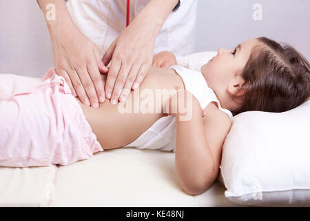 Pediatrician doing abdominal examination with hands Stock Photo