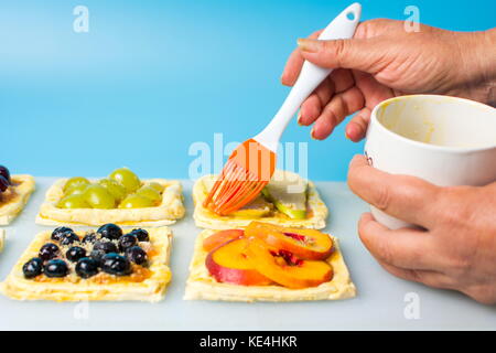 Chef applying egg on the fruit sweet pie before baking Stock Photo