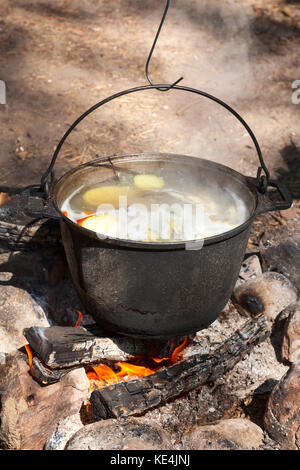 Cooking fish soup on camping bonfire Stock Photo