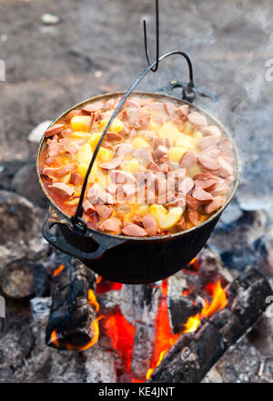 Cooking soup in cast iron boiler on burning campfire. Pot with soup over  the open fire outdoors. Tourism in Latvia. Soup cooking on the fire outdoor  f Stock Photo - Alamy