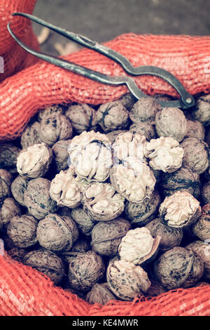 Vintage toned close up picture of walnuts in a bag on a local market, selective focus. Stock Photo