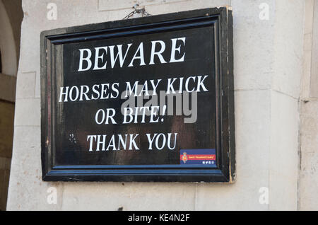 ’Beware horses may kick or bite’ warning sign on a wall. Stock Photo