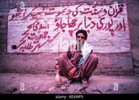 A young man with his water-pipe, Peshawar, Pakistan Stock Photo