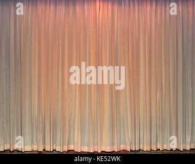 White curtains Curtains cover a  cinema screen, with pink columns at both sides. Stock Photo