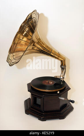 Early gramophone with large brass horn on round wooden base ...