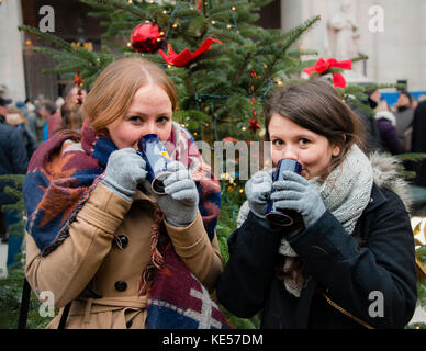 Two young women drink mulled wine, Christmas market, Salzburg, Austria Stock Photo