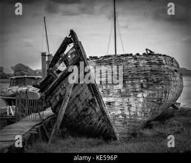 Rotten hulk of boat in mud of Benfleet Creek, Essex, at low tide ...