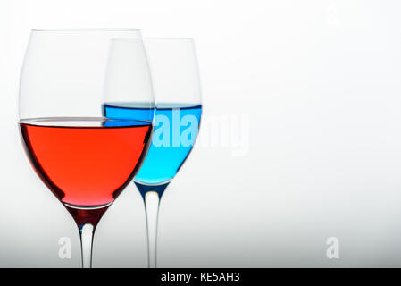 two glasses with blue colored water and red wine Stock Photo