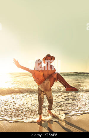 Portrait playful young couple on sunny summer ocean beach Stock Photo