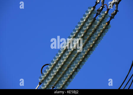 Close up of insulator discs on power lines  of a lattice tower Stock Photo