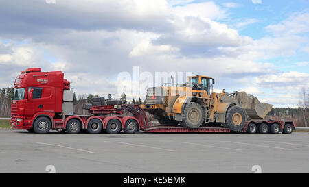 FORSSA, FINLAND - APRIL 23, 2016: Scania 164G truck stops at Forssa truck stop during the oversized transport of heavy Volvo L350F wheel loader, side  Stock Photo