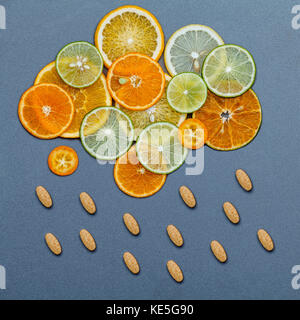 Healthy foods and medicine concept. Pills of vitamin C and citrus fruits in the shape of cloud and raining. Citrus fruits sliced lime,orange and lemon Stock Photo
