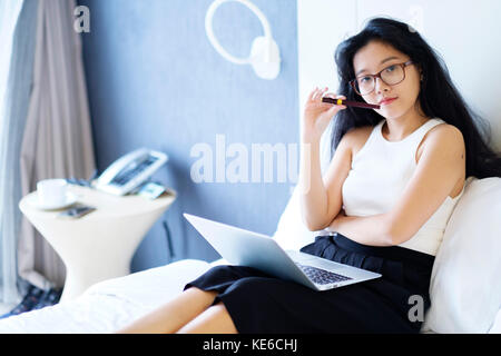 Asian woman professional using laptop computer sitting on sofa working ...