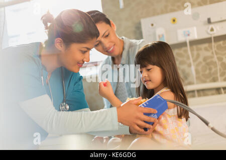 Female nurse helping girl patient in hospital room Stock Photo