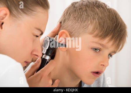 Close-up Of Female Doctor Examining Boy's Ear With An Otoscope Stock Photo