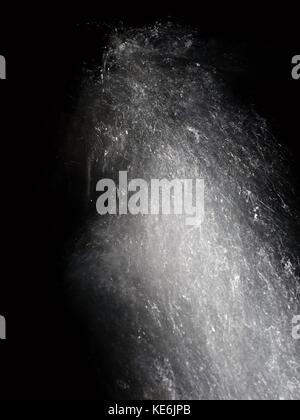 Shinning drops. Cascade of small weir on mountain stream, water is running over blocks and bubbles create milky smoky water level. Abstract, long expo Stock Photo