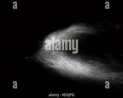 Shinning drops. Cascade of small weir on mountain stream, water is running over blocks and bubbles create milky smoky water level. Abstract, long expo Stock Photo