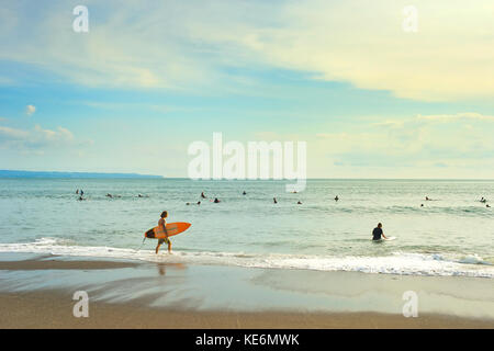 CANGGU, BALI ISLAND, INDONESIA - JAN 19, 2017: Surfers going to surf in the ocean. Bali island is one of the worlds best surfing destinations Stock Photo