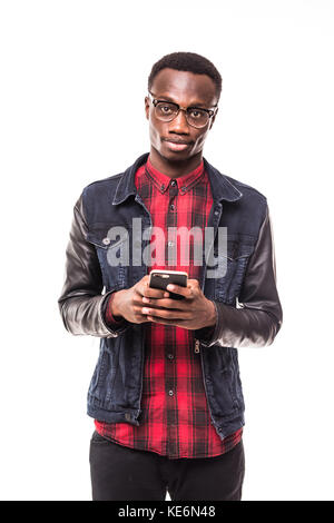 Portrait of young smiling african male student, typing sms on his phone, on pure white Stock Photo