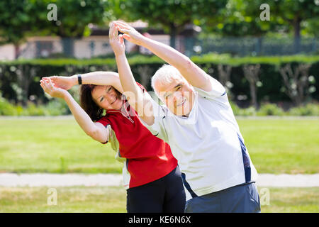Photo Of Senior Couple Exercising Together At Park Stock Photo