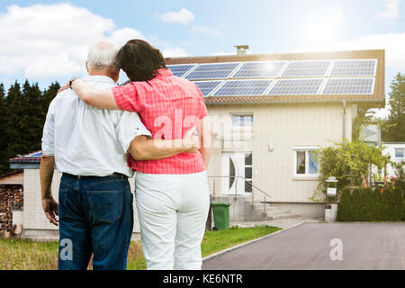 Senior couple standing in front of clock tower Stock Photo - Alamy