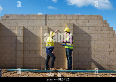 civil engineer and worker discussing issues at the construction site Stock Photo