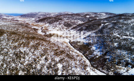 Creek with running Thredbo river between snow covered Snowy mountains in Kosciuszko national park of Australia, NSW, on a sunny winter day. Stock Photo