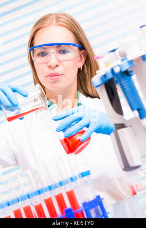 A female lab assistant doing scientific experiments in a scientific laboratory Stock Photo