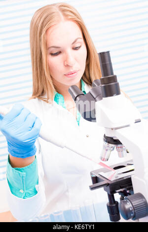 A female lab assistant doing scientific experiments in a scientific laboratory Stock Photo