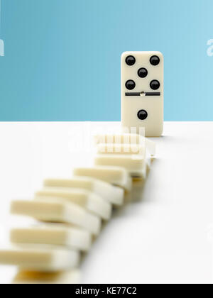Domino toppling row of dominos Stock Photo