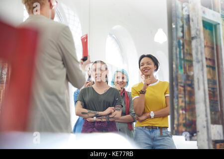 Students listening to instructor in art class studio Stock Photo