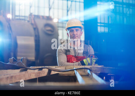Portrait tough male worker working in factory Stock Photo