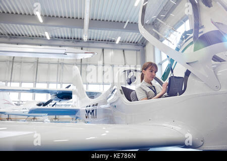 Female pilot in cockpit of small airplane Stock Photo